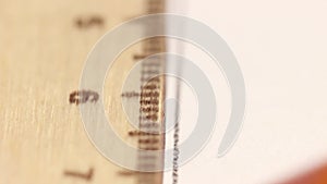 Macro photography of a wooden ruler, on which a line is drawn with a pencil.