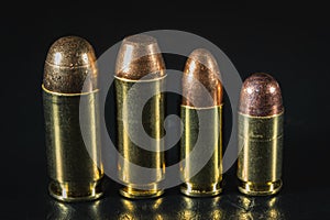 Macro photos of pistol cartridges of caliber 45, 10mm, 9mm and 380