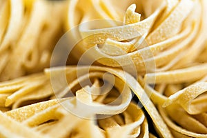 Macro pictore of traditional Italian raw pasta Tagliatelle, selective focus image. Vegeterian food. Nutrition concept. Italian