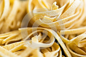 Macro pictore of traditional Italian raw pasta Tagliatelle, selective focus image. Vegeterian food. Nutrition concept. Italian photo