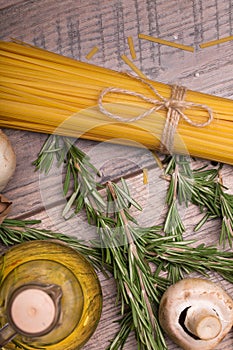 Macro picture of yellow uncooked pasta, mushroom, quail eggs and rosemary. Uncooked ingredients on a wooden table