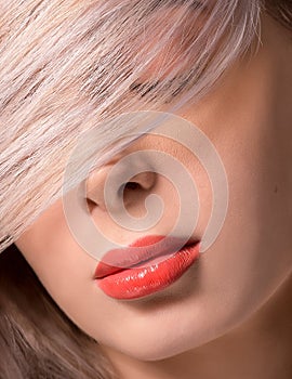 Macro of Platinum Blonde Hair Woman With Blue Eyes and Augmented Lips, Painted With Coral Lipstick, With Eyes Closed, Covered with