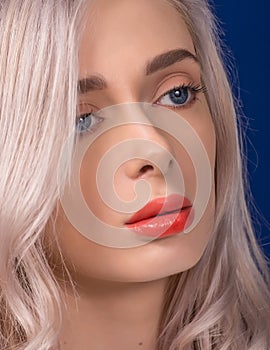 Macro of Platinum Blonde Hair Woman With Blue Eyes and Augmented Lips, Painted With Coral Lipstick, Looking from Profile