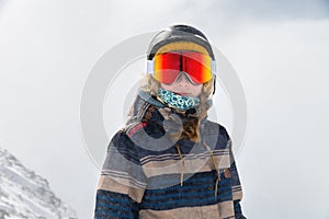 Macro portrait. Young adult woman, snowboarder or skier in a snowy winter on a mountain slope