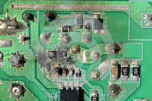 Macro of the rearside of a circiut board of some cheap electronic equipment. Some small components have exploded, and the board is photo