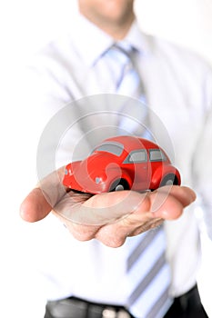 Macro red toy car in businessman hand