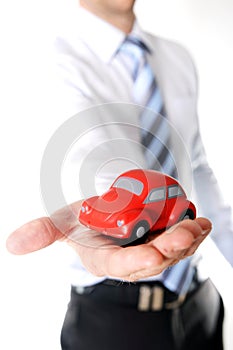 Macro red toy car in businessman hand