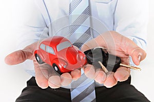 Macro red toy car with car keys in mans hand