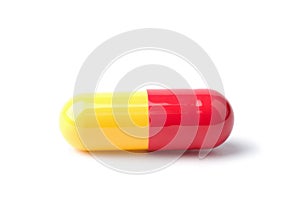 Macro of red and yellow capsule pill isolated photo