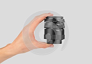 Macro rings for a camera in a male hand on a gray background