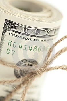 Macro Roll of One Hundred Dollar Bills Tied in Burlap String on White