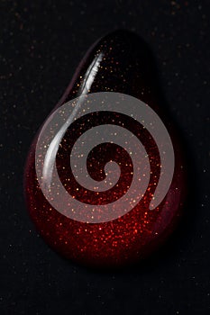 Macro ruby drop nail polish glitter background