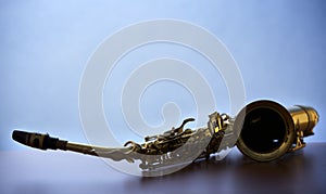 Macro of saxophone on wooden board, backlit