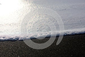 Macro sea foam on Icelandic black sand