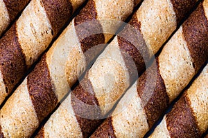 Macro selective focus on chocolate wafer rolls. Chocolate sticks background