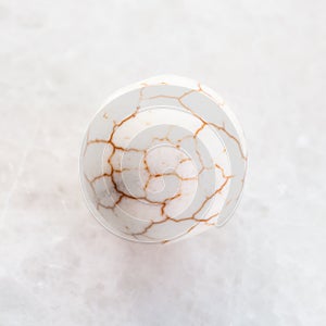 ball from cracked Cacholong gemstone on white photo