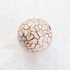 bead from cracked Cacholong gemstone on white photo