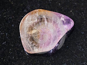 polished Ametrine gemstone on dark background photo