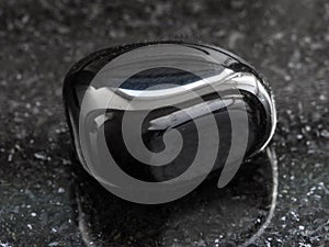 polished black Onyx gemstone on dark photo