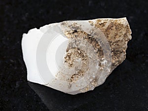 raw cacholong (white opal) stone on dark photo