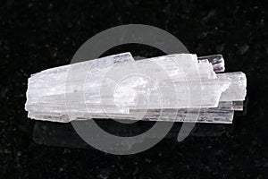 raw crystal of Scolecite gemstone on dark photo