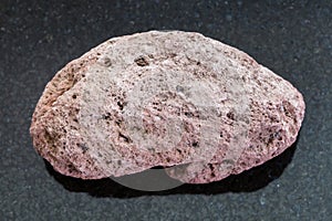 red pumice pebble on dark background