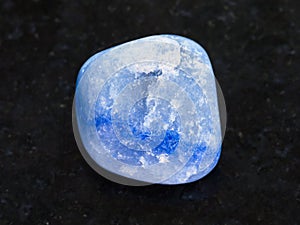 tumbled blue dyed agate gemstone on dark