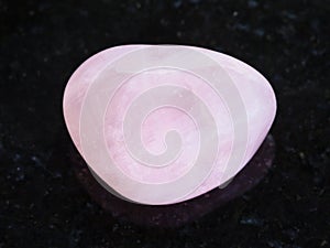 tumbled Rose Quartz gem stone on dark photo