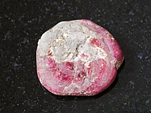 tumbled Thulite gemstone on dark background photo