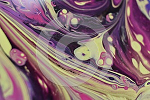 Macro shot of an abstract background of poured colorful acrylic paint and oil mixture