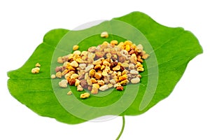 Macro shot of bee pollen on green nasturtium leaf white background. Raw brown, yellow, orange and blue flower pollen