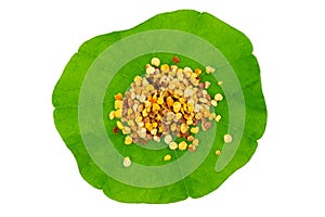 Macro shot of bee pollen on green nasturtium leaf white background. Raw brown, yellow, orange and blue flower pollen