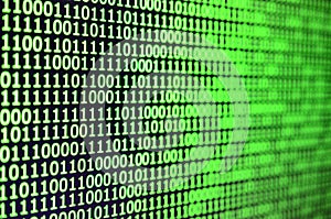 Macro shot of binary code on the monitor of an office computer. The concept of the programmer`s work. The flow of digital informa