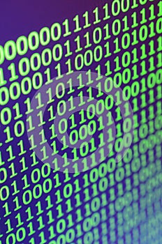 Macro shot of binary code on the monitor of an office computer. The concept of the programmer`s work. The flow of digital informa