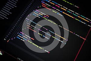 Macro shot of colorful programming code on computer screen, showcasing software development, coding process, and error handling in