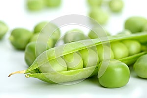 Macro shot of cracked pod and green peas