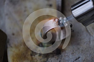 Macro shot. Craft jewelery making with professional tools. A handmade jeweler process, manufacture of jewellery. Melting