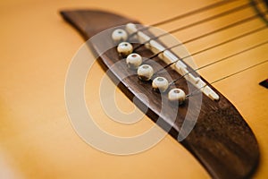 Macro shot down the fretboard of acoustic guitar with shallow depth of field