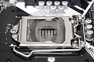 Macro shot of empty modern LGA 1200 socket for CPU on black desktop motherboard.
