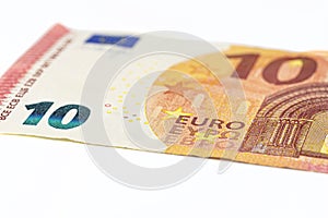 Macro shot of a European Union banknote of 10 EUR, close-up of the number ten, isolated on a white background, selective focus.