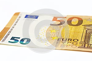 Macro shot of a European Union banknote of 50 EUR, close-up of the number fifty, isolated on a white background, selective focus.