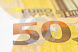 Macro shot of a European Union banknote of 50 EUR, close-up of the number fifty, selective focus