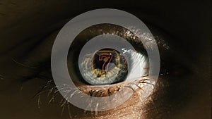 Macro shot of eyes with lucky number seven reflection. Jackpot casino concept.