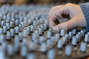 Macro shot of a hand in a control panel of a music recording studio