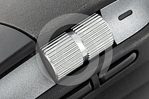 A macro shot of a metal roller from a modern wireless computer mouse.