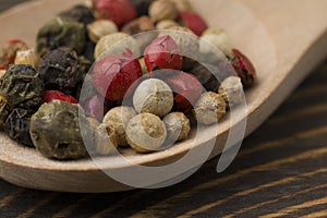 Macro shot of Mixed of peppers hot, red, black, white in wood spoon