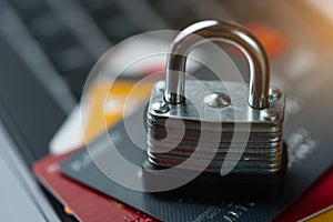 Macro shot of multicolored credit cards with lock on laptop keyboard background. Finance transaction or transfer online pay money