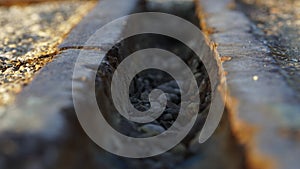 Macro shot of an old rusty train rail in sunset light with some pebbles