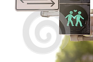 macro shot of a pedestrian traffic light modified for a LGBTQ event showing a green graphic of loving same sex gay men couple