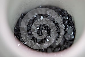 Macro shot of pure cadmium telluride element crystals in a container